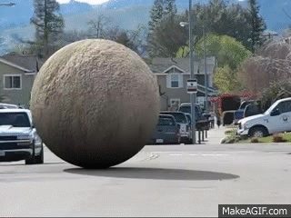 Giant_ball_rolling_down_street.gif